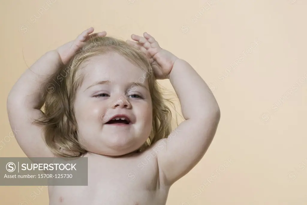 A young girl raising her arms