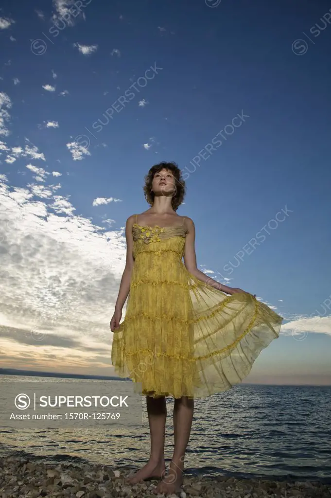 A woman wearing a dress standing by the sea