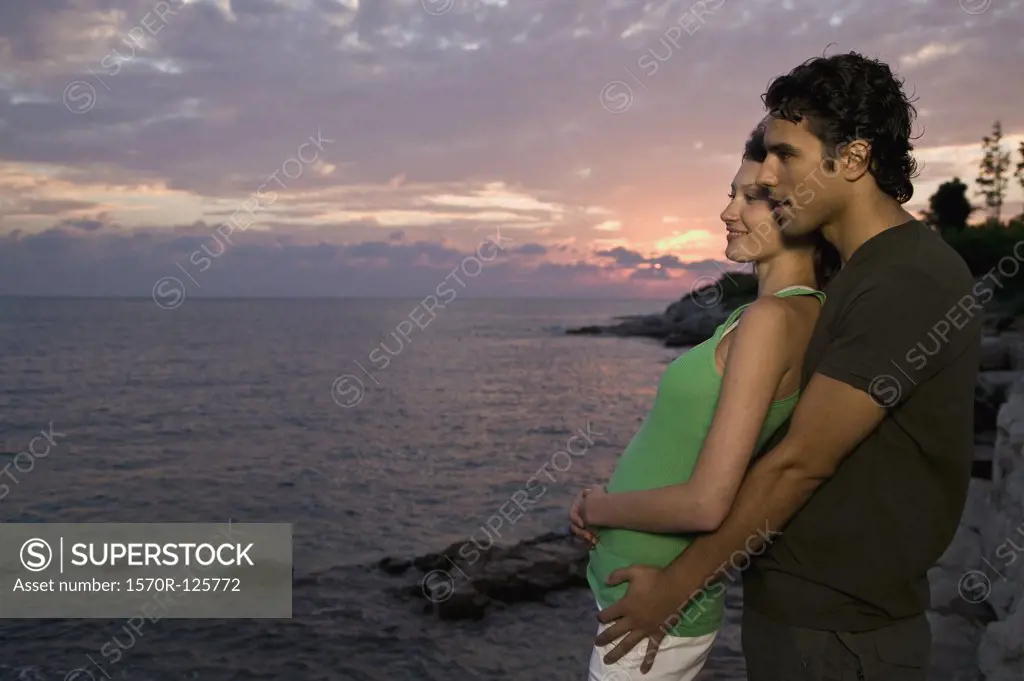 A young couple standing on a cliff