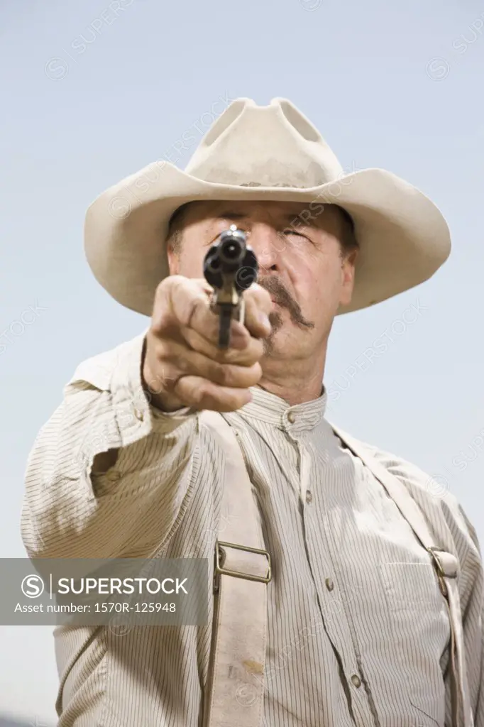 Portrait of a cowboy aiming his gun ready to shoot