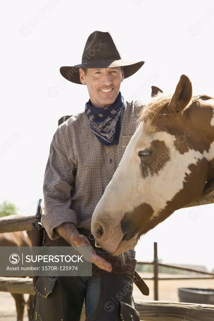 A rancher standing with his horse
