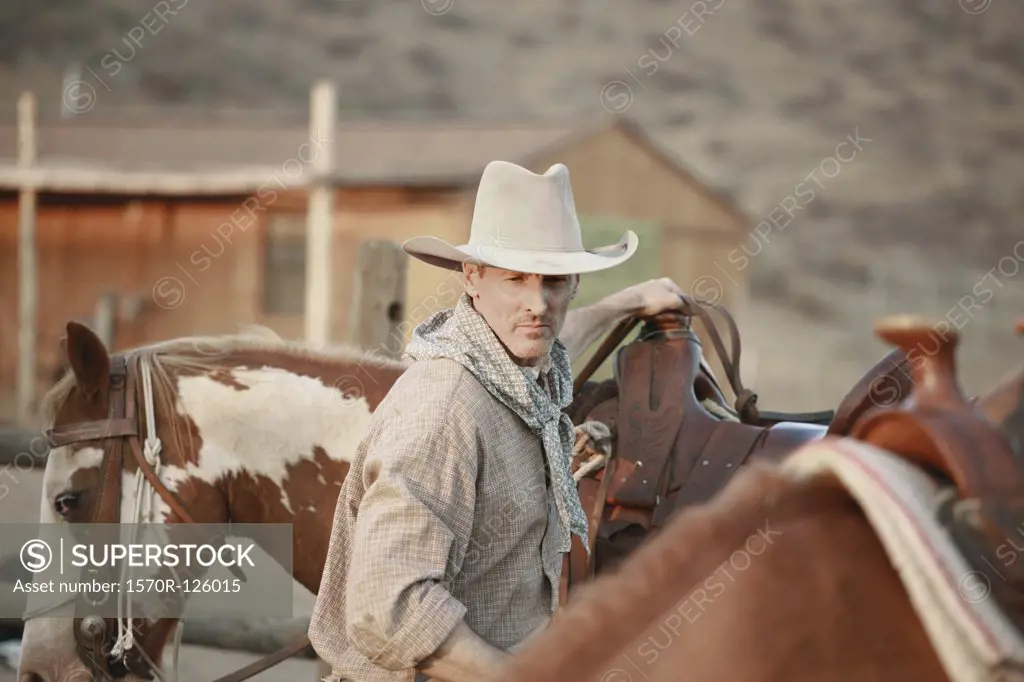 A cowboy working on a ranch with horses