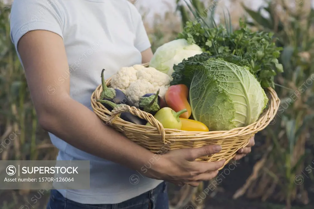 A teenage girl carrying a basket of vegetables