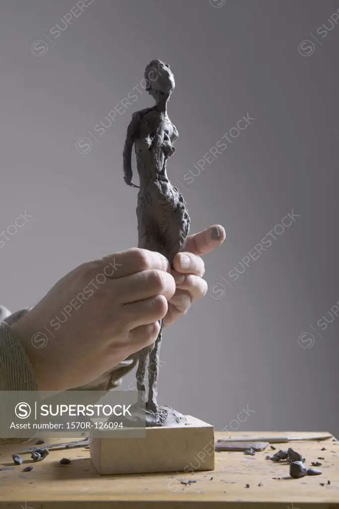 Human hands working on a sculpture