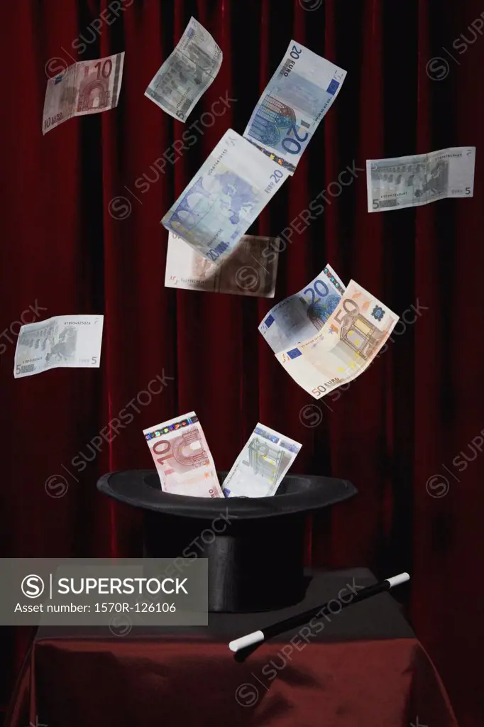 European Union currency bills coming out of a top hat at a magic show