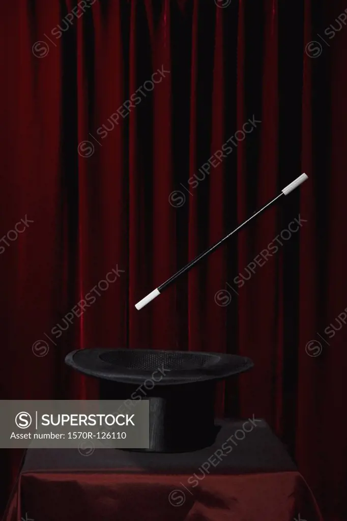 A magic wand hovering over a top hat