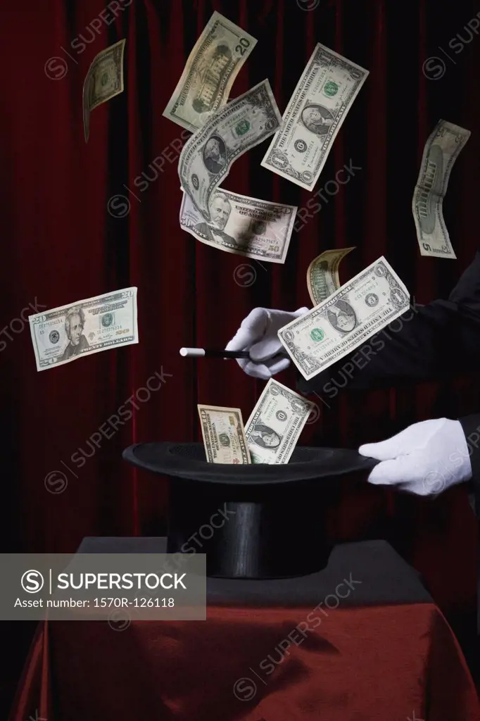 A magician performing magic by making money come out of a hat