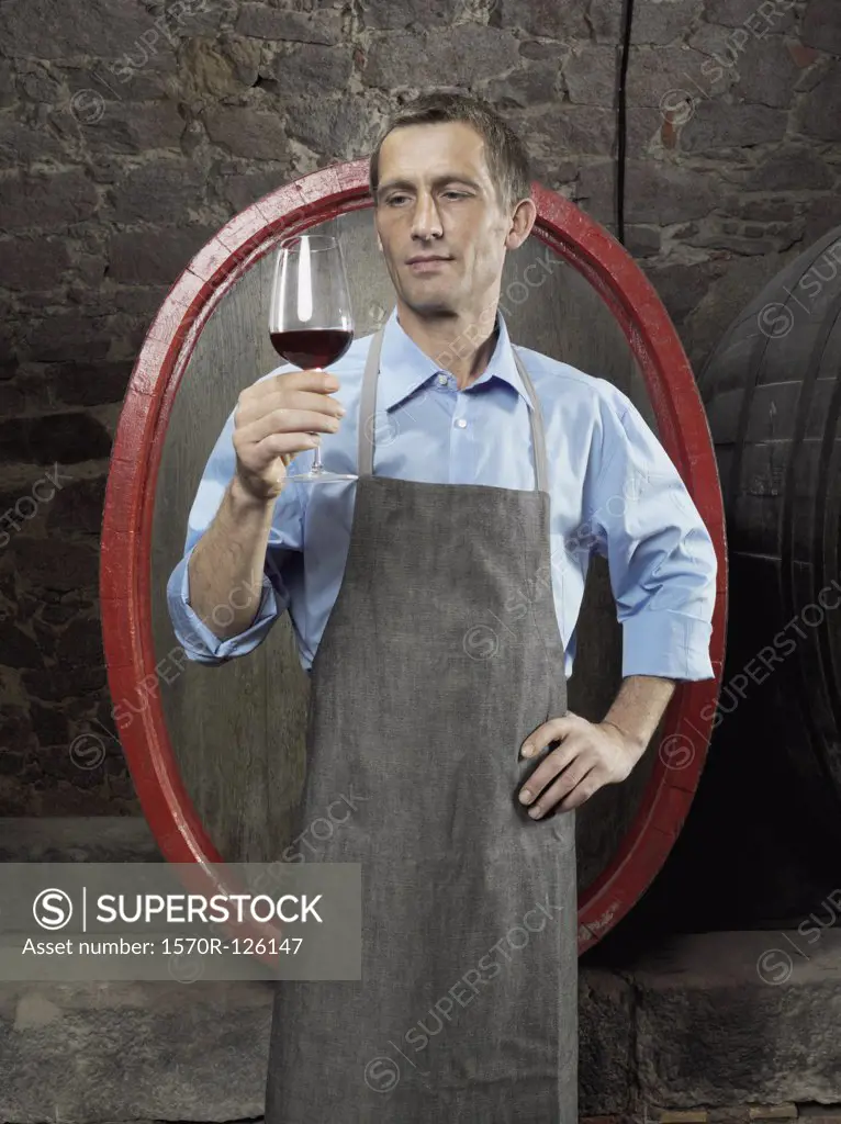A vintner studying red wine in a glass