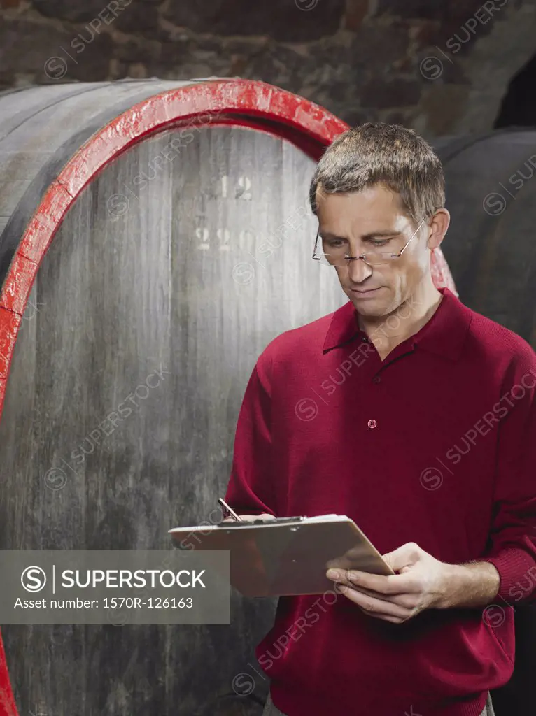 A vintner writing on a clipboard