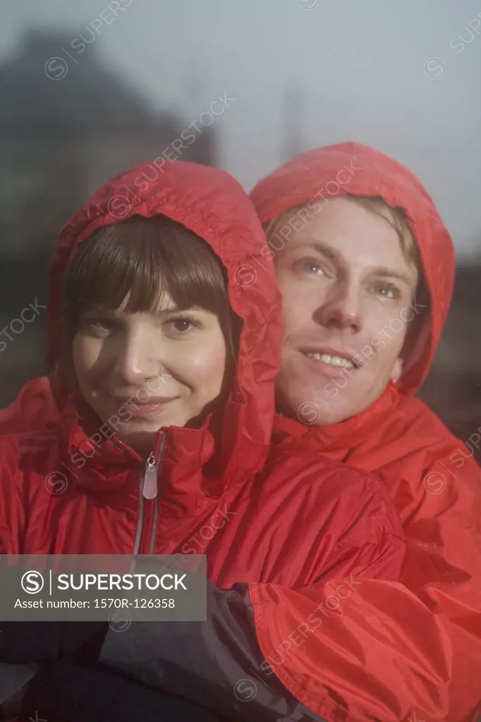 Young couple wearing raincoats