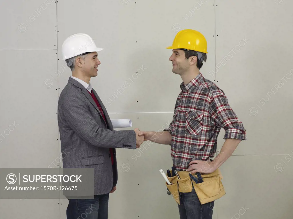 An architect shaking hands with a construction worker