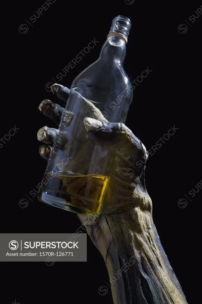 Monster's hand holding a bottle