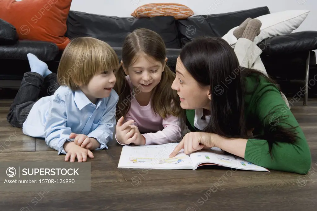 A mother reading a book to her two children