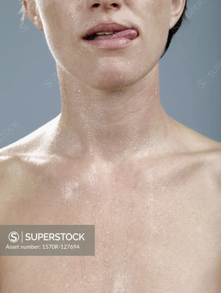 A woman with wet skin licking her lips