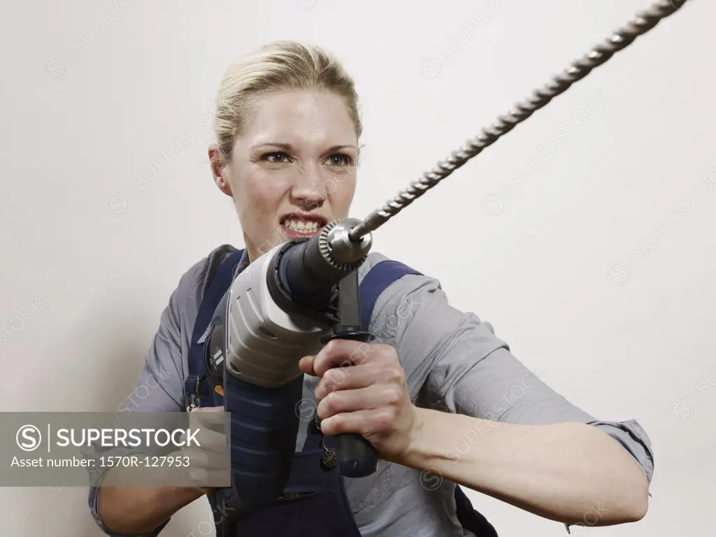A woman holding a drill