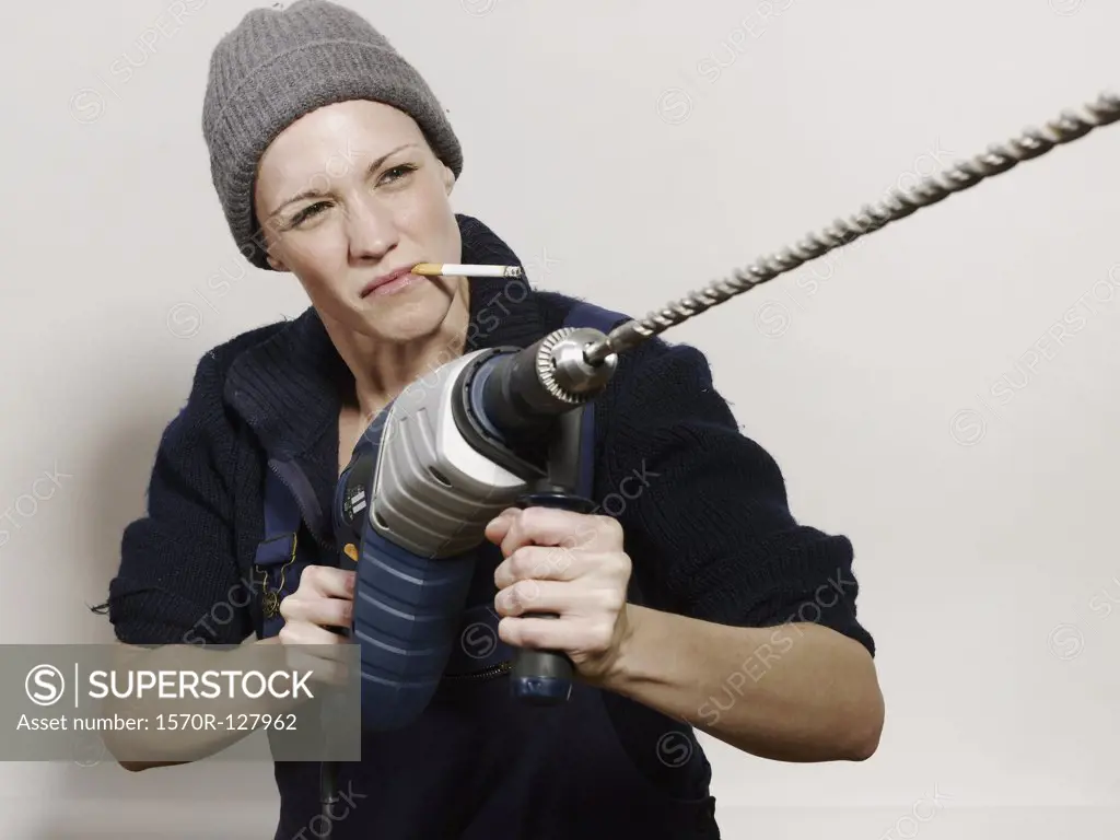 A woman holding a large drill