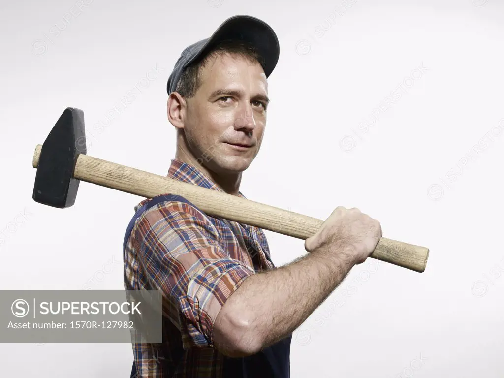 A man holding a sledgehammer over his shoulder