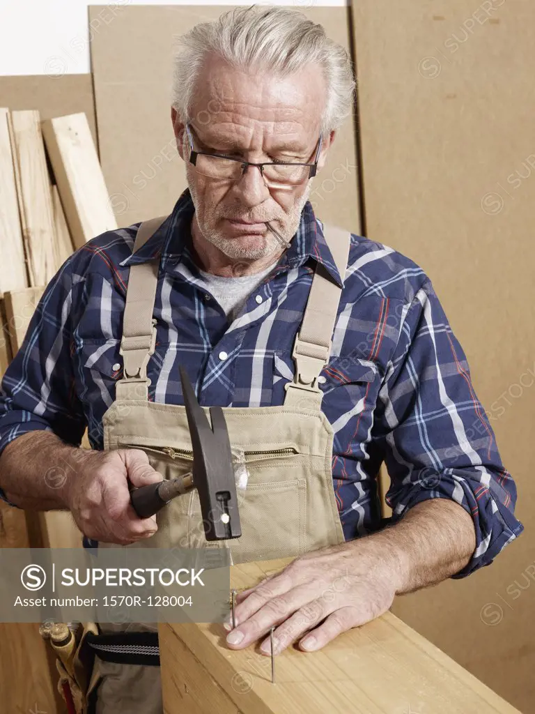 A man hammering nails into wood