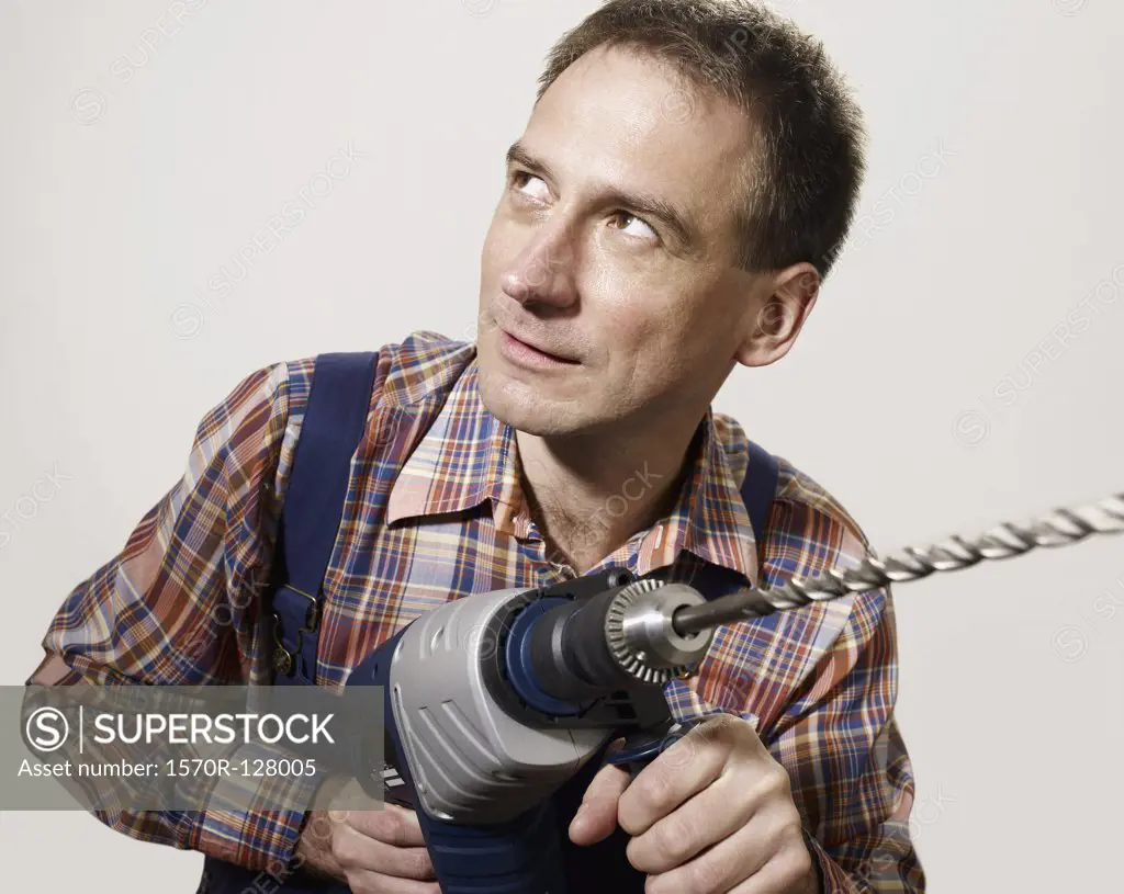 A man holding a large drill