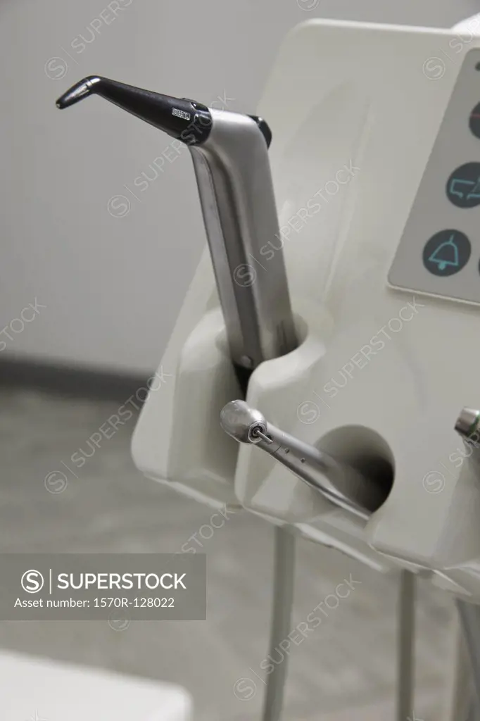 A drill and a suction device docked in a dental examination room 