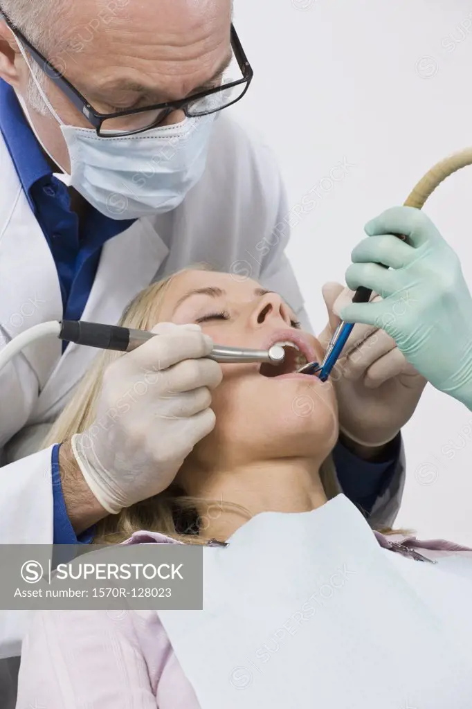 A dentist inspecting a woman's mouth