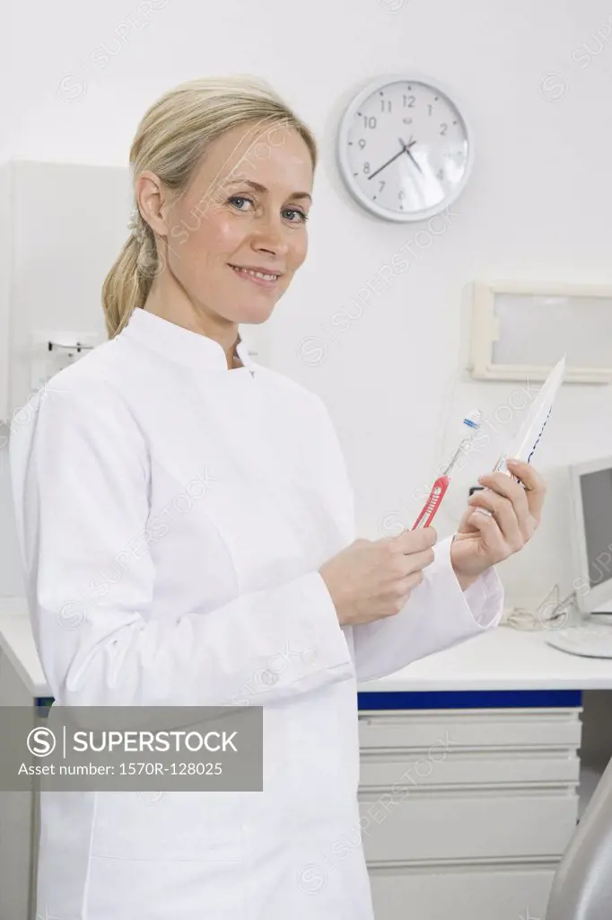 A dental assistant holding a toothbrush and toothpaste