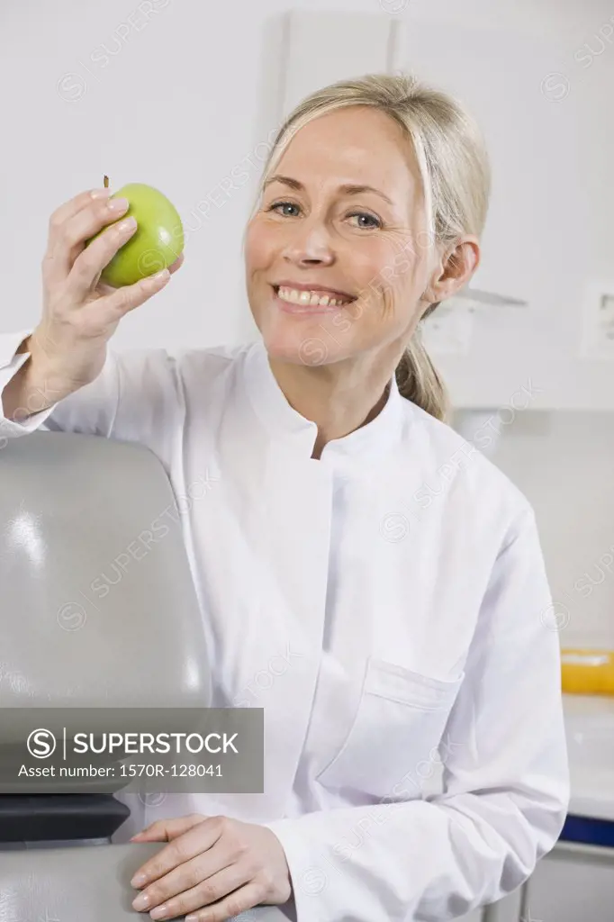 Portrait of a dental assistant holding an apple