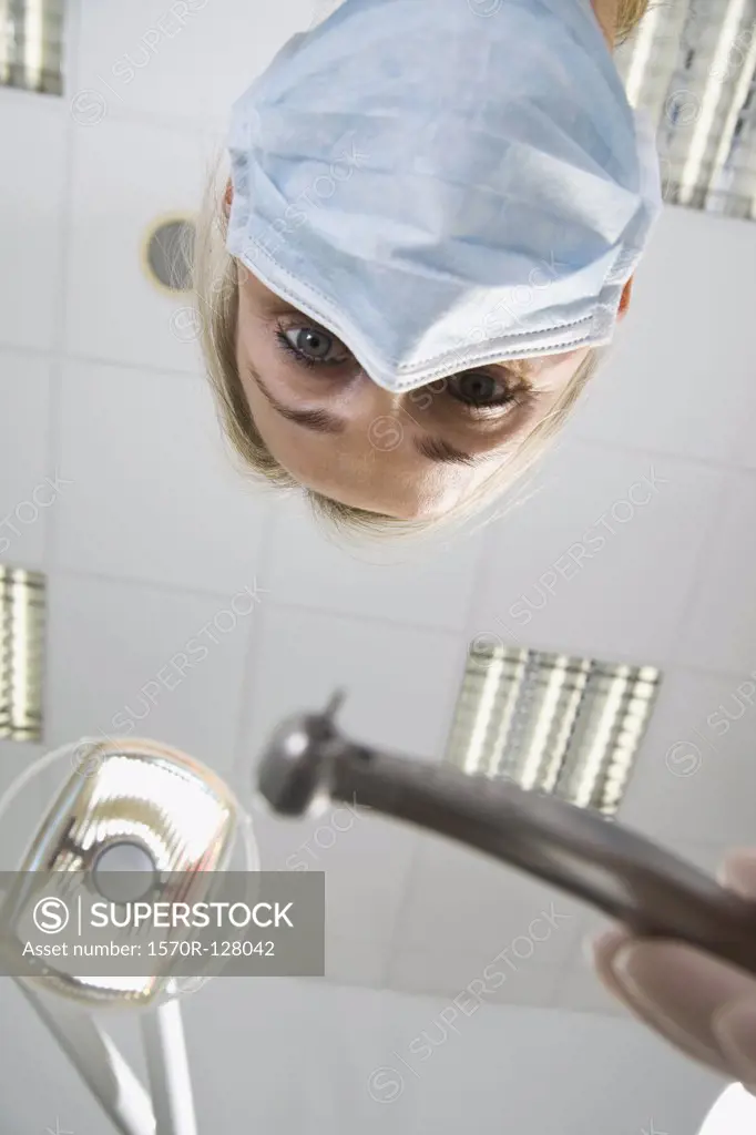View from below of a dentist holding s drill