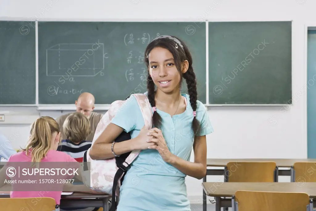 Portrait of a schoolgirl standing in a classroom