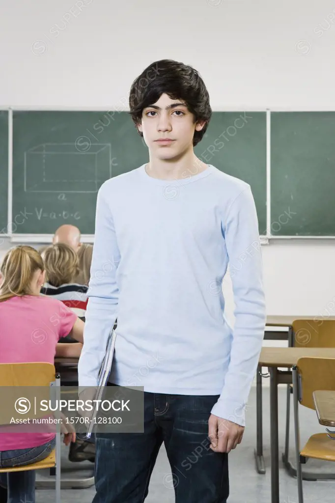 Portrait of a schoolboy standing in a classroom