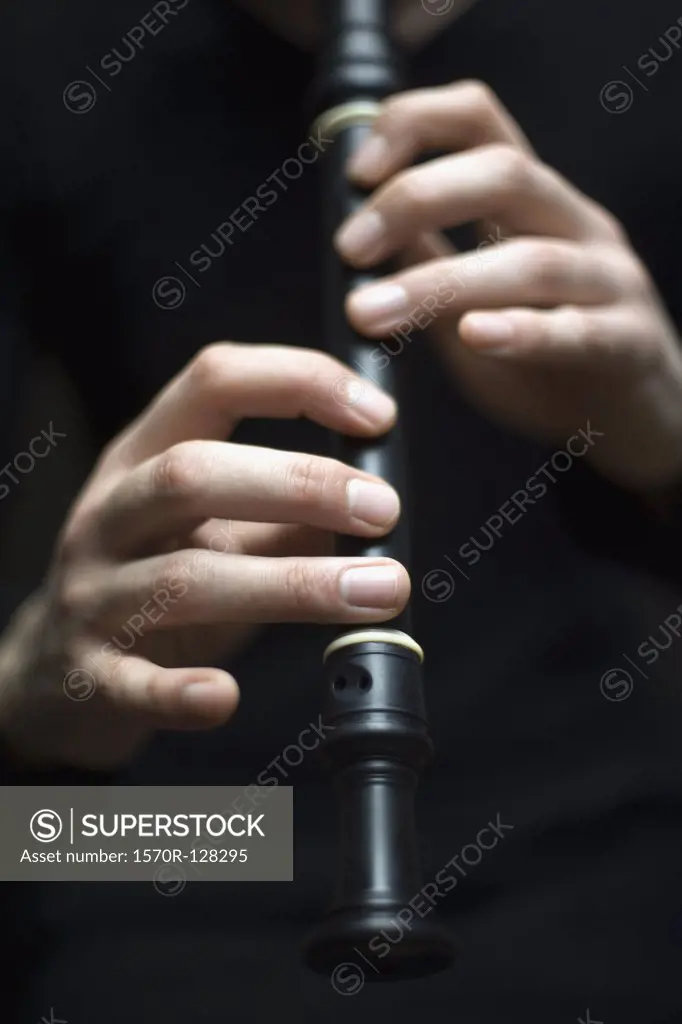 Human hands playing a recorder