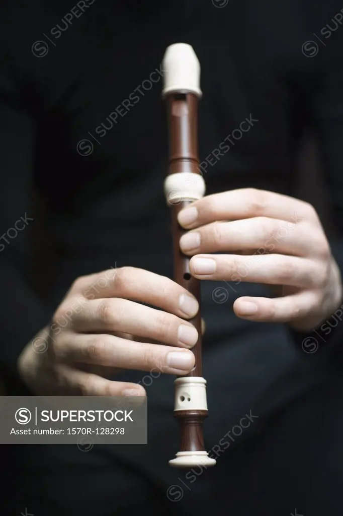 Human hands playing a recorder