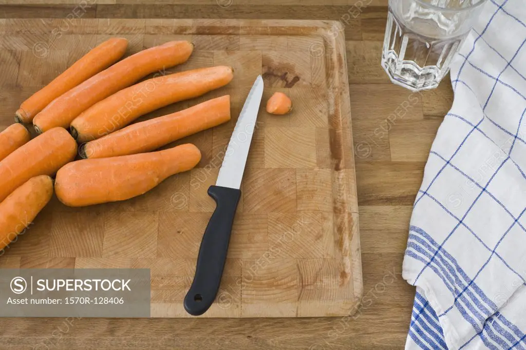 A cutting board with knife and carrots, still life