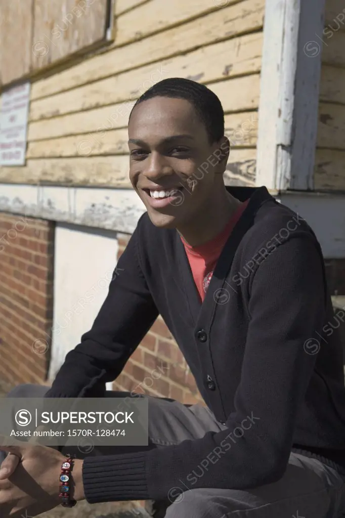 A young man sitting on porch steps
