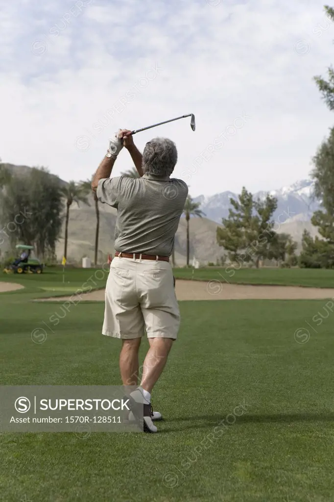 Rear view of a man playing golf, Palm Springs, California, USA