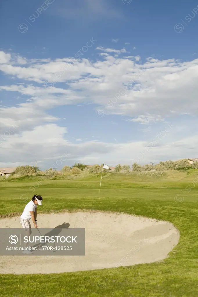 A golfer playing from a sand bunker
