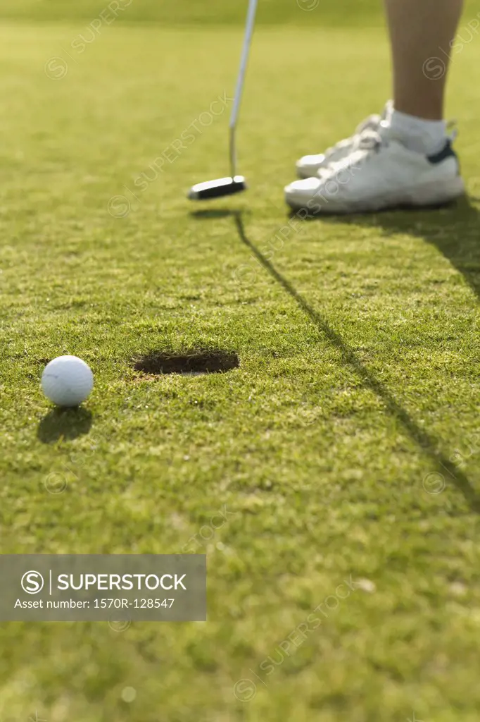 Detail of a golf ball next to a hole