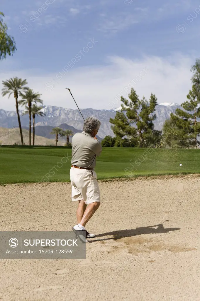A golfer playing from a sand bunker, Palm Springs, California, USA