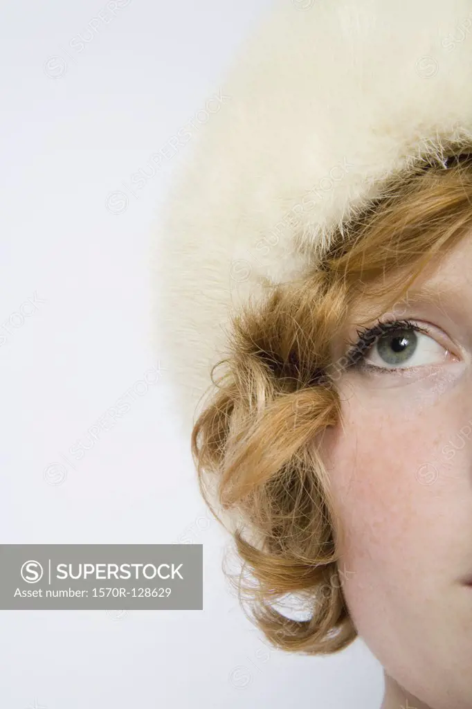 A woman with curly red hair wearing a fur hat
