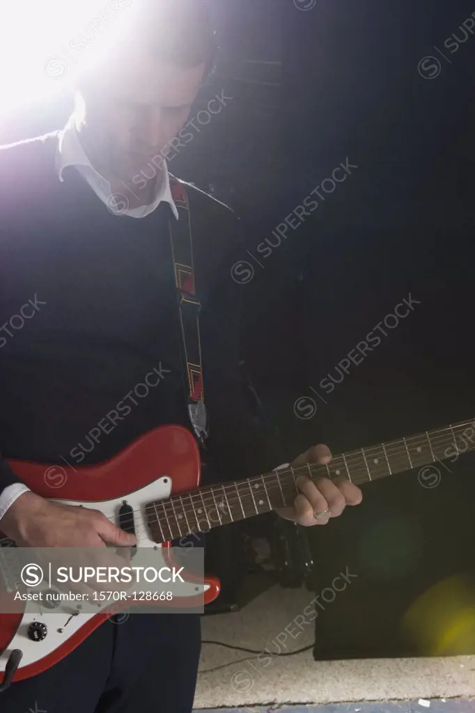 A man playing an electric guitar on stage