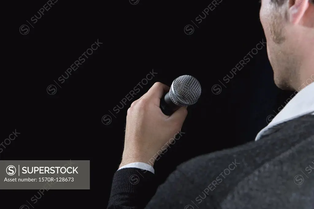 Rear view of a man holding a microphone