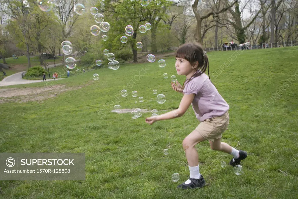 A young girl catching bubbles in Central Park, New York City