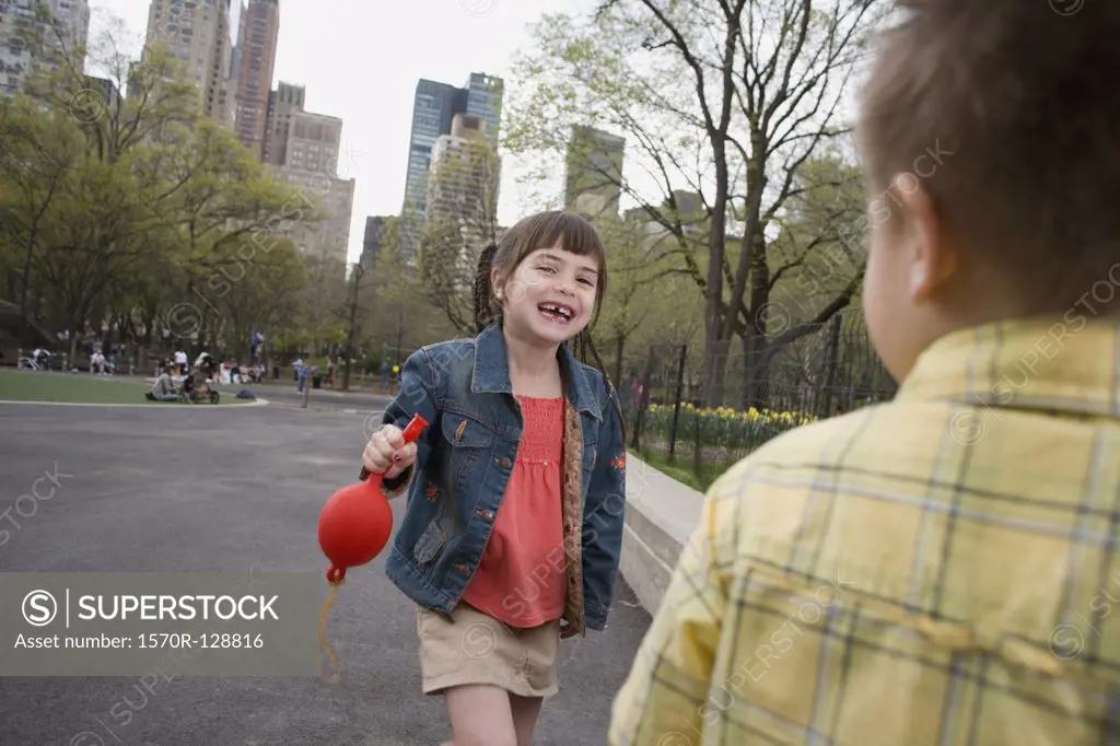 A young girl holding a balloon in Central Park, New York City