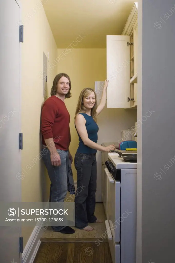 Portrait of a young couple standing in a kitchen