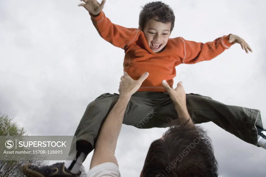 A father throwing his son into the air