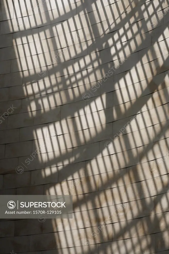 Sunlight and shadow of bars on a stone wall