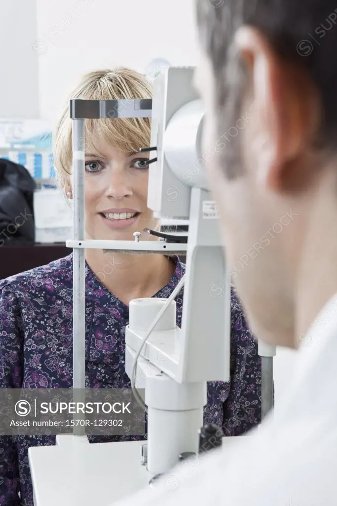 A patient being examined with a slit-lamp biomicroscope by an ophthalmologist