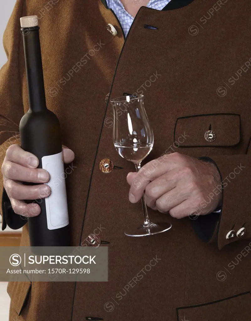 A man holding a bottle and glass of Schnapps