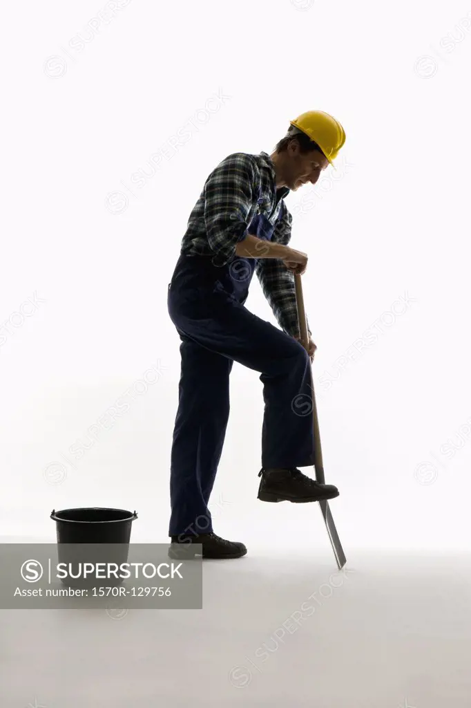 A construction worker digging with a shovel