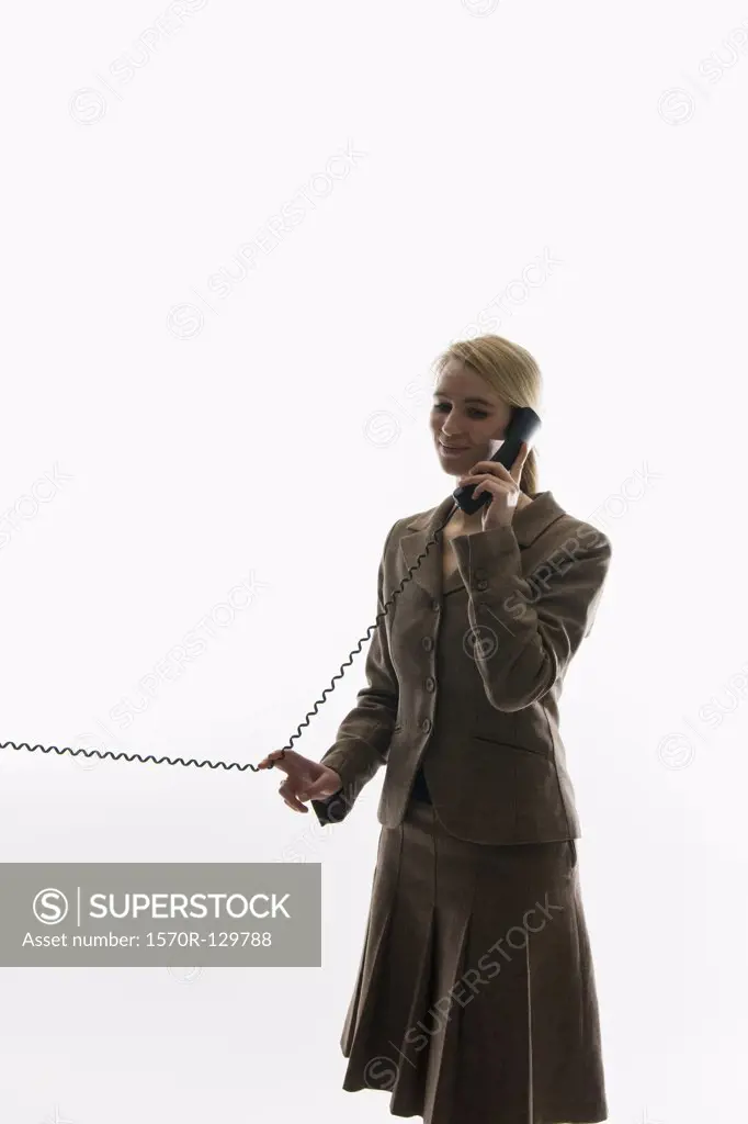 A businesswoman using a landline phone